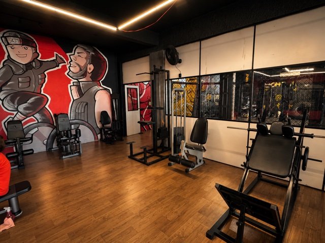 Equipamentos de musculação junto ao mural da academia